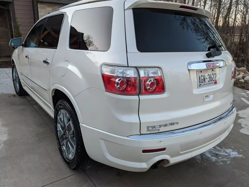 Rear driver side view of a white SUV, showcasing the polished finish and high-gloss shine after detailing.