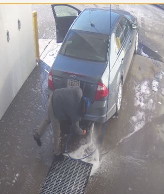 Person washing an exhaust system with water, risking serious damage.