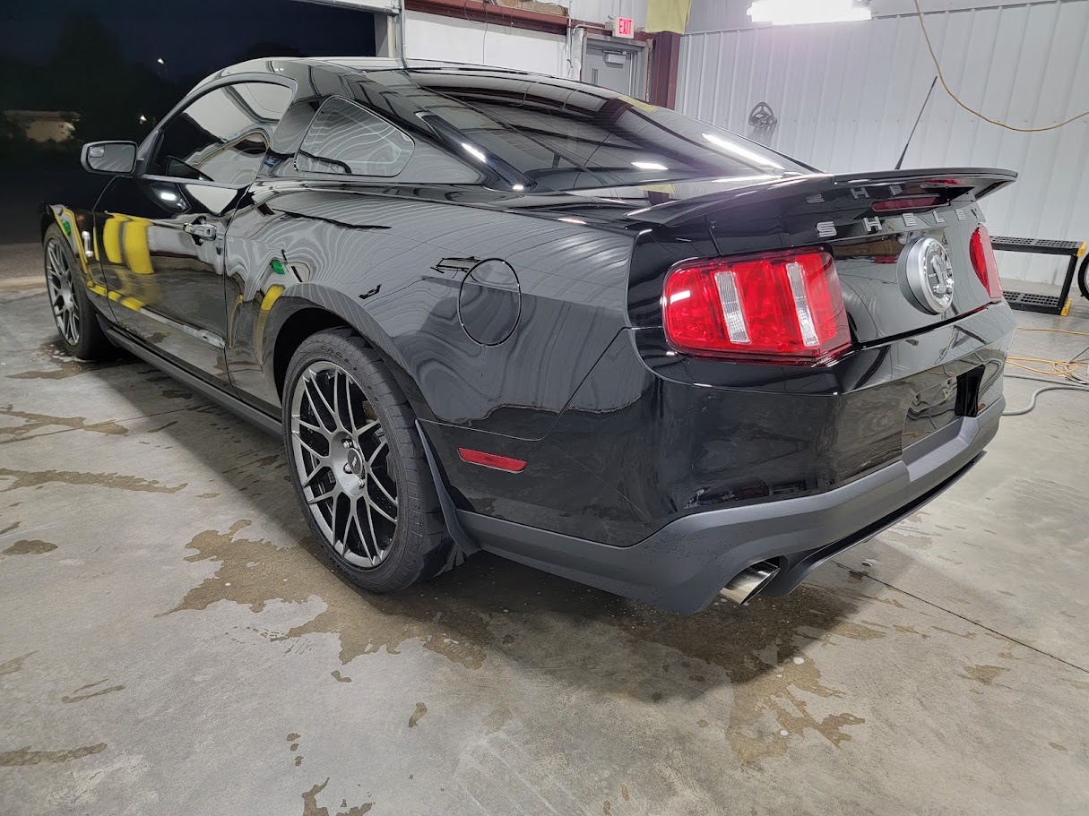 Cobra Shelby GT500 after clay bar and paint correction, reflecting bright shop lights before ceramic coating is applied